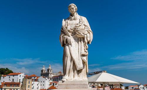 Low angle view of statue against blue sky