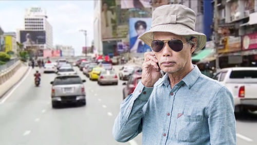 Man wearing sunglasses standing on street in city