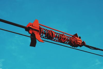 Low angle view of machinery against blue sky