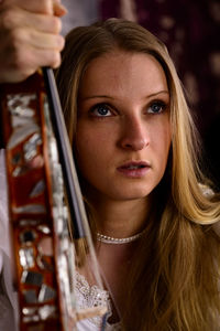 Close-up of beautiful young woman wearing angel costume holding violin