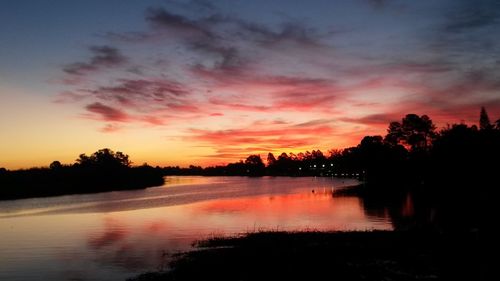 Scenic view of lake against romantic sky at sunset