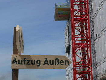 Text on construction site against sky