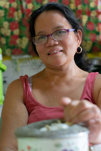 Portrait of mature woman with food sitting at home