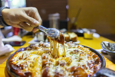 Close-up of hand holding ice cream on table