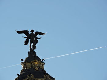 Low angle view of statue against clear blue sky