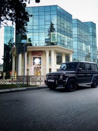 Cars on road against sky in city