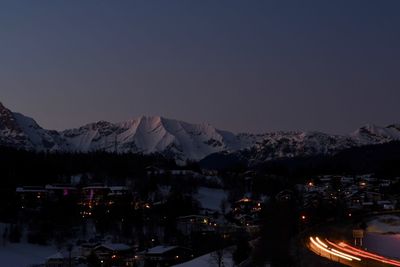 Illuminated buildings in city against sky at night