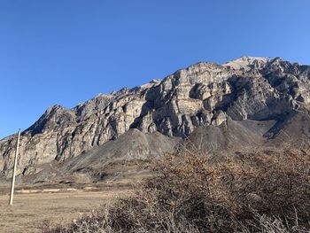 Scenic view of rocky mountains against clear blue sky