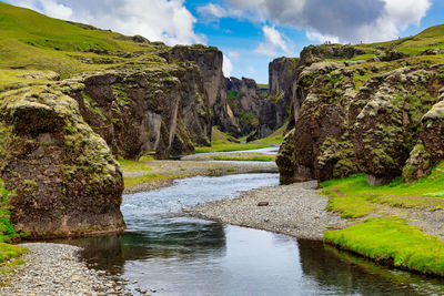 Scenic view of river amidst rocks against sky