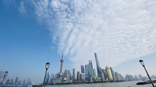 Buildings in city against cloudy sky