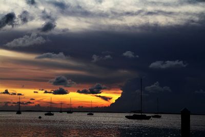 Silhouette of sailboats in sea during sunset