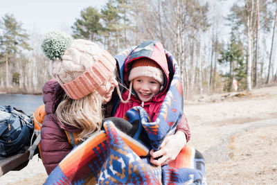 Mom and daughter laughing and hugging whilst having a picnic