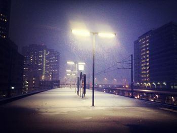 View of illuminated street lights in city at night