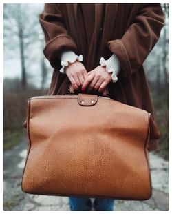 Midsection of man holding camera