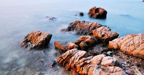 Rocks in sea against sky