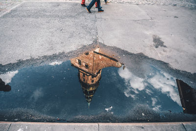 Low section of person in puddle on street