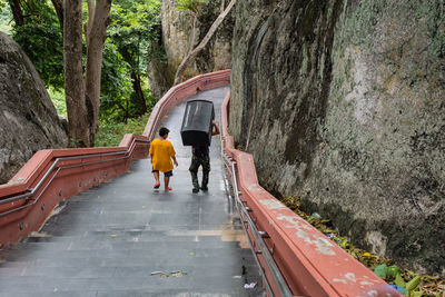 Rear view of people walking on footbridge