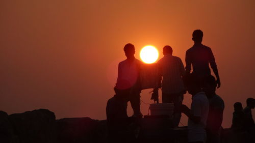 Silhouette people against sky during sunset