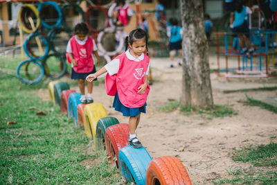 Rear view of siblings playing outdoors