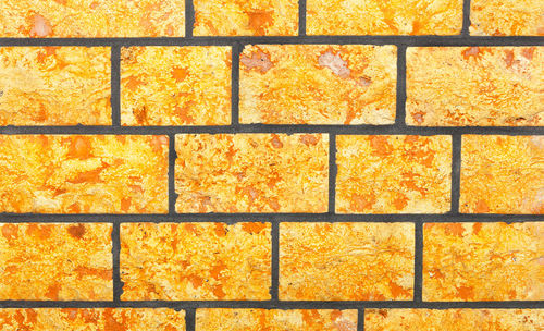 The background and texture of the wall is made of hewn bright yellow stone in the form .