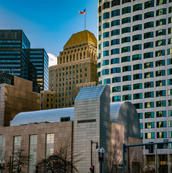 Low angle view of modern buildings against blue sky