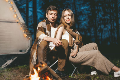 Young couple sitting on wood