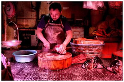 Butcher cutting meat in shop