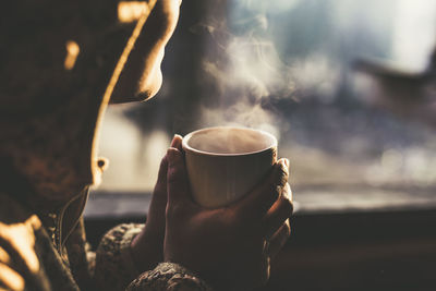 Close-up of hand holding coffee cup