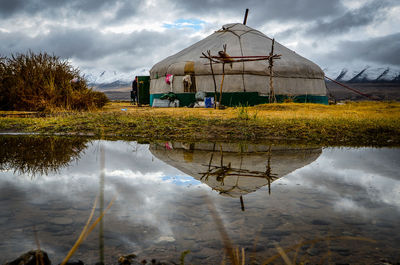 Reflection of building in lake against sky