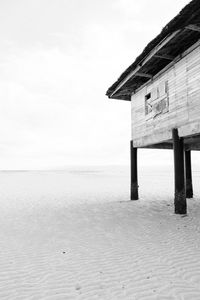 Built structure on beach by sea against sky