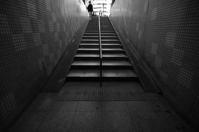 Low section of man walking on staircase