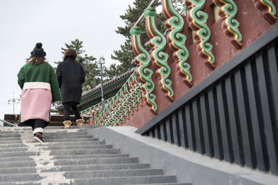 Rear view of people on railing against sky