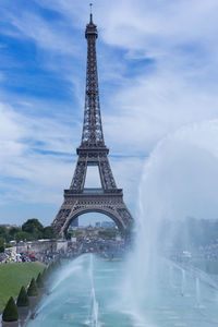 Water fountain in city against sky