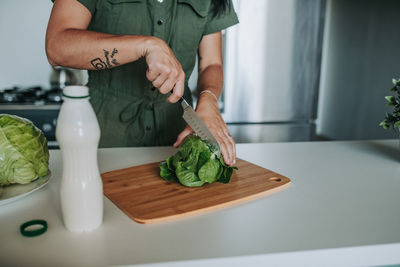 Woman cutting vegetables at kitchen counter