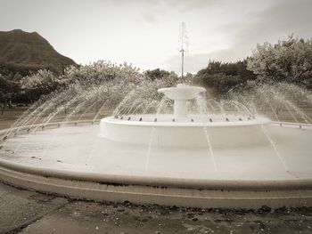 Fountain in park against sky