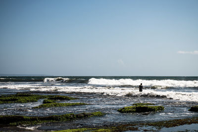 Man surfing in sea against sky