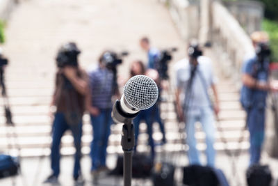 Close-up of microphone against people