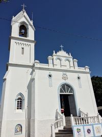 Low angle view of bell tower against blue sky