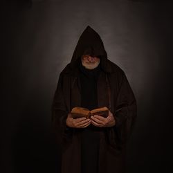 Rear view of man standing against black background
