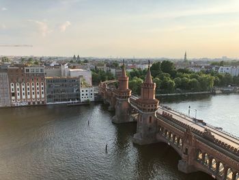 Bridge over river against buildings in city