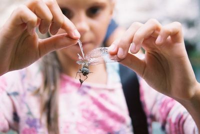 Close-up of girl holding insect