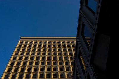 Low angle view of modern building against clear blue sky