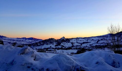 Scenic view of mountains against clear sky during winter