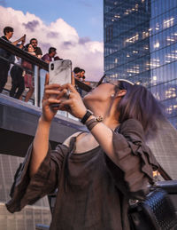 Man photographing with mobile phone in city