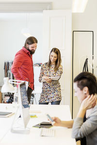 Business people discussing over document in creative office