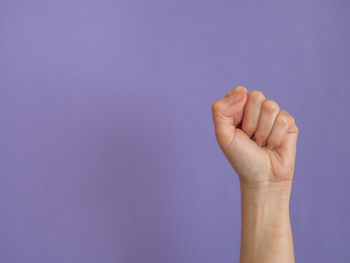 Close-up of human hand against blue background