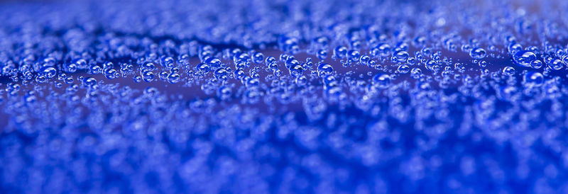 Full frame shot of raindrops on blue water