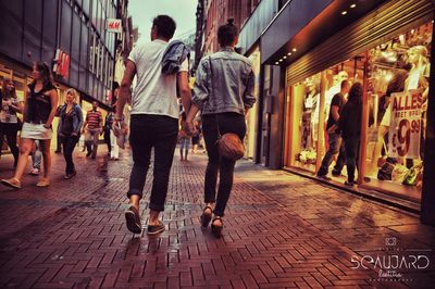 People walking on street amidst buildings in city