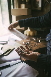 Cropped image of gay man holding work tool in garage