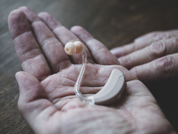 Hearing device in hand of elder person. world hearing day